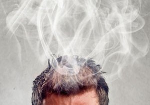 Hombre-pensando-con-los-ojos-cerrados-poniendo-sus-dedos-sobre-sus-sienes-mientras-le-sale-humo-de-su-cabeza-300x211.jpg